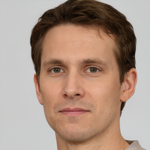 Joyful white young-adult male with short  brown hair and green eyes