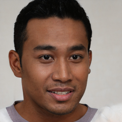 Joyful latino young-adult male with short  black hair and brown eyes