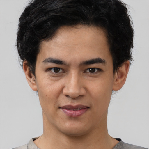 Joyful latino young-adult male with short  brown hair and brown eyes