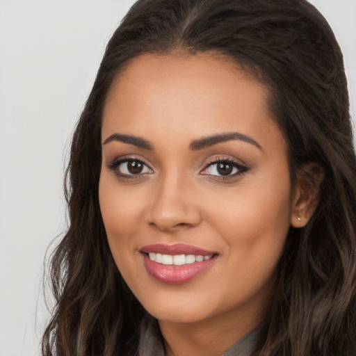 Joyful latino young-adult female with long  brown hair and brown eyes