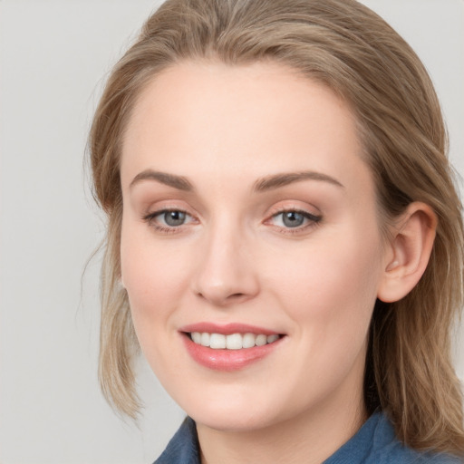 Joyful white young-adult female with medium  brown hair and blue eyes