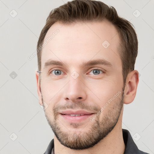 Joyful white young-adult male with short  brown hair and grey eyes