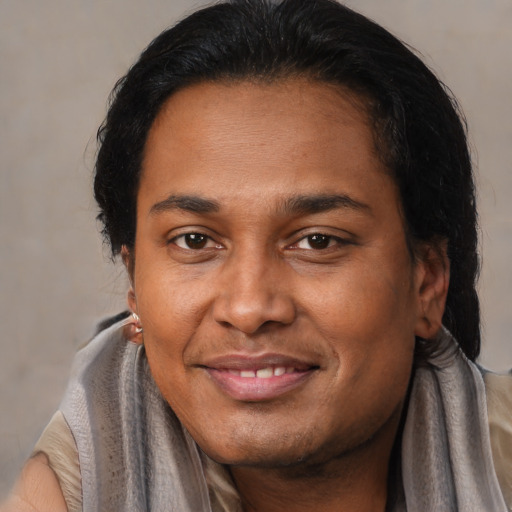 Joyful latino adult male with short  brown hair and brown eyes