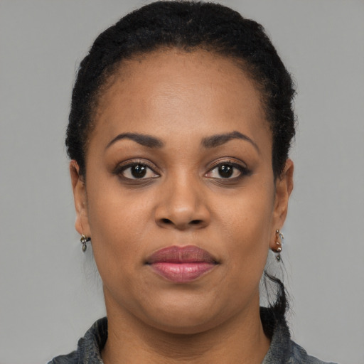 Joyful black adult female with short  black hair and brown eyes