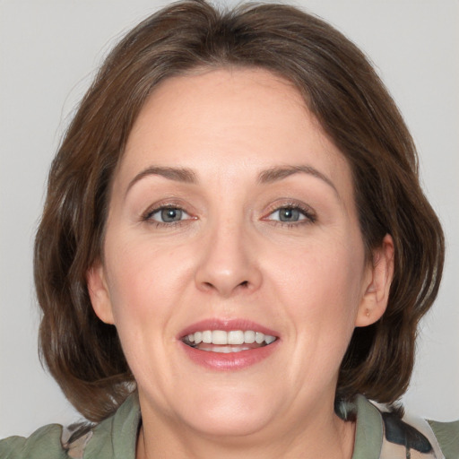 Joyful white adult female with medium  brown hair and grey eyes