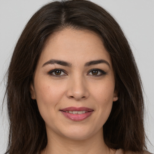 Joyful white young-adult female with long  brown hair and brown eyes