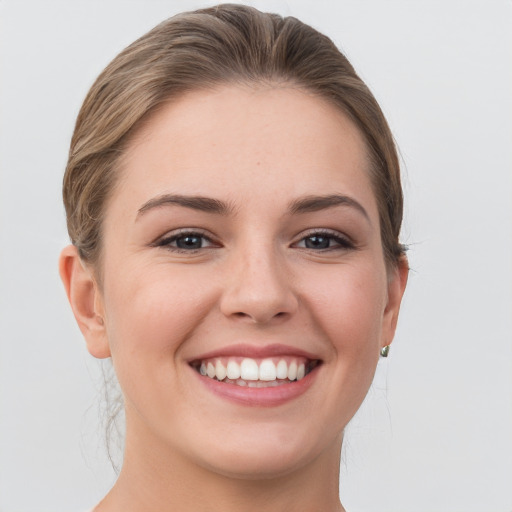 Joyful white young-adult female with short  brown hair and grey eyes