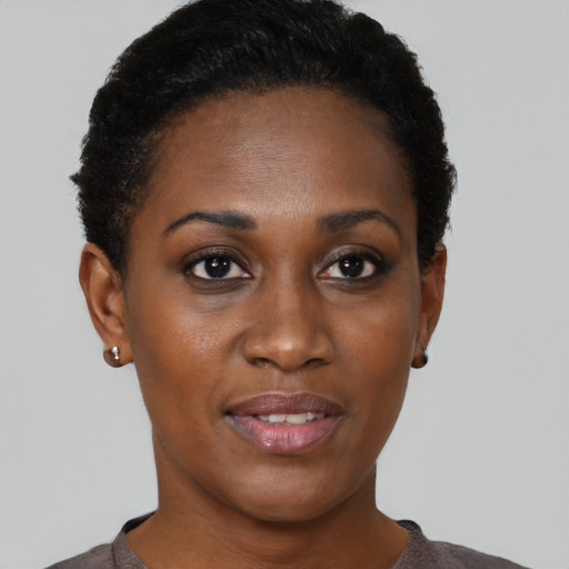 Joyful black young-adult female with short  black hair and brown eyes