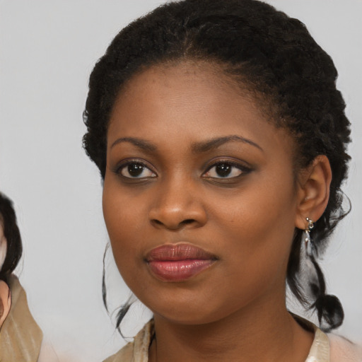 Joyful black young-adult female with medium  brown hair and brown eyes