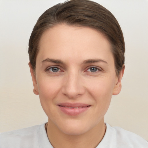 Joyful white young-adult female with short  brown hair and grey eyes