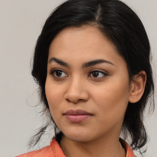 Joyful latino young-adult female with medium  black hair and brown eyes