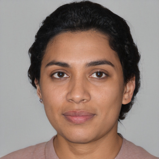 Joyful latino young-adult female with short  black hair and brown eyes
