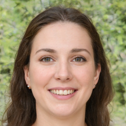 Joyful white young-adult female with long  brown hair and green eyes