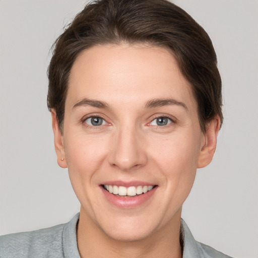 Joyful white young-adult female with short  brown hair and grey eyes