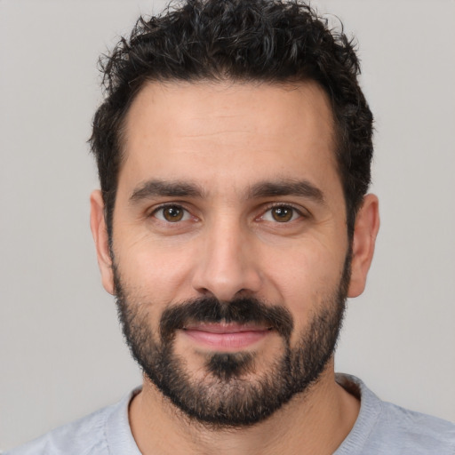 Joyful white young-adult male with short  black hair and brown eyes