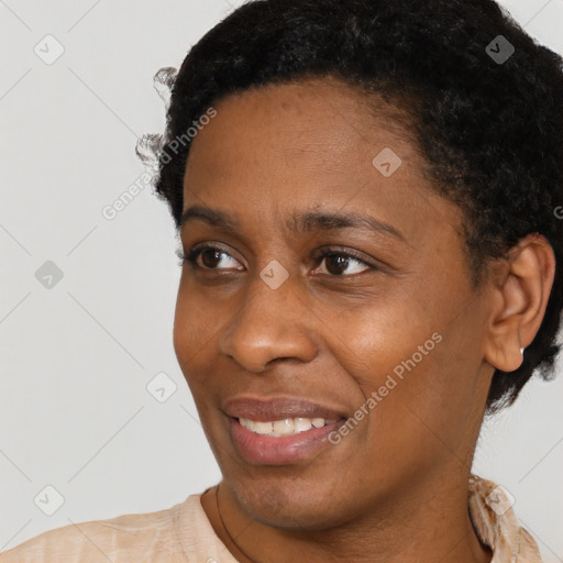 Joyful black young-adult female with short  black hair and brown eyes