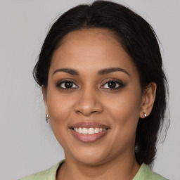 Joyful latino young-adult female with medium  brown hair and brown eyes