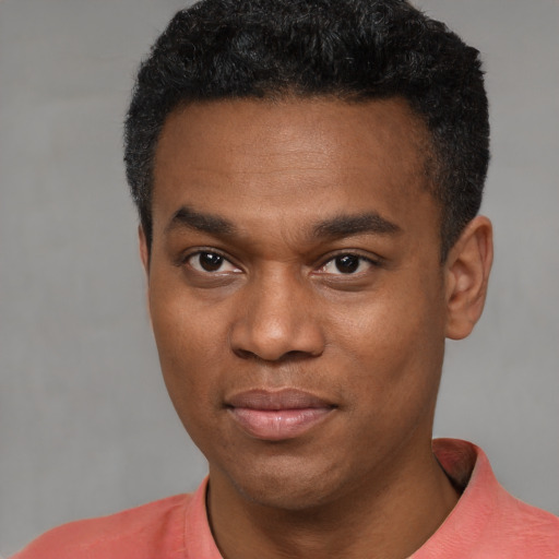 Joyful black young-adult male with short  black hair and brown eyes