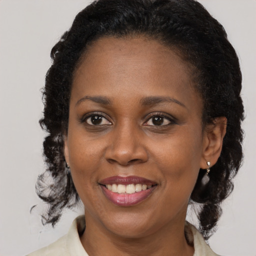 Joyful latino adult female with medium  brown hair and brown eyes