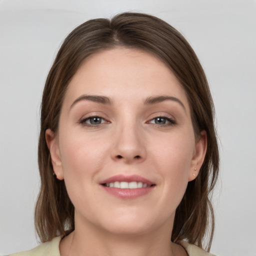 Joyful white young-adult female with medium  brown hair and grey eyes