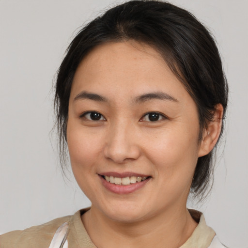 Joyful asian young-adult female with medium  brown hair and brown eyes