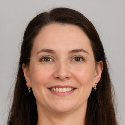 Joyful white adult female with long  brown hair and grey eyes