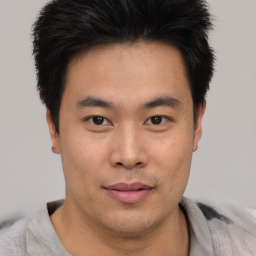 Joyful asian young-adult male with short  brown hair and brown eyes