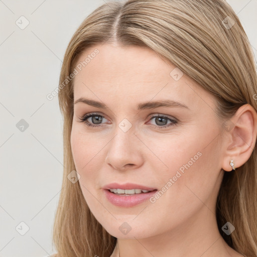 Joyful white young-adult female with long  brown hair and blue eyes