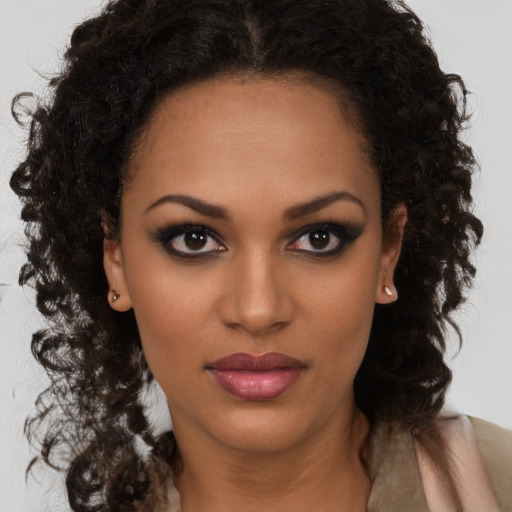 Joyful black young-adult female with long  brown hair and brown eyes