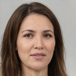 Joyful white adult female with long  brown hair and brown eyes