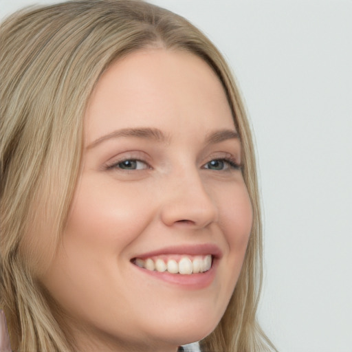 Joyful white young-adult female with long  brown hair and blue eyes