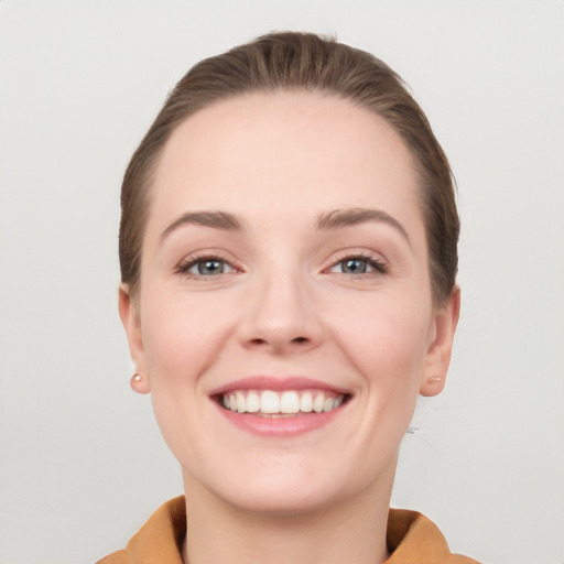 Joyful white young-adult female with short  brown hair and grey eyes