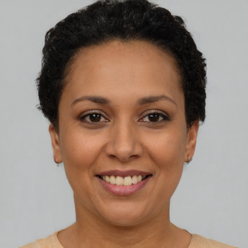 Joyful latino adult female with short  brown hair and brown eyes