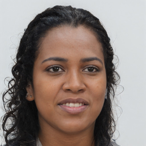 Joyful black young-adult female with long  black hair and brown eyes