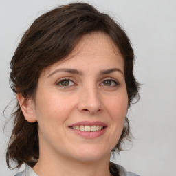 Joyful white young-adult female with medium  brown hair and green eyes