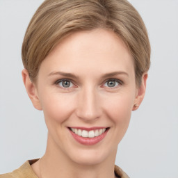 Joyful white young-adult female with short  brown hair and grey eyes