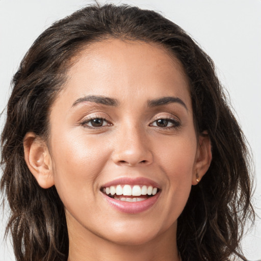 Joyful white young-adult female with long  brown hair and brown eyes