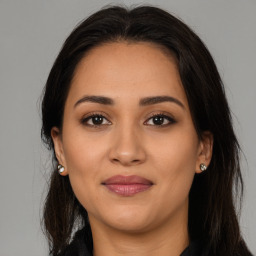 Joyful latino young-adult female with long  brown hair and brown eyes