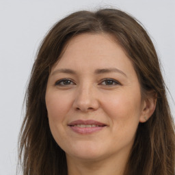 Joyful white adult female with long  brown hair and brown eyes