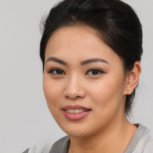 Joyful asian young-adult female with short  brown hair and brown eyes