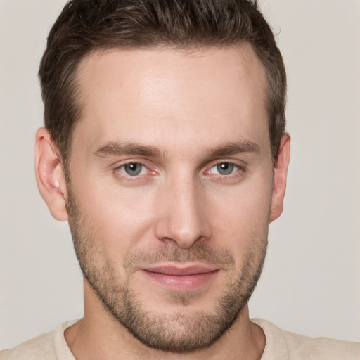 Joyful white young-adult male with short  brown hair and grey eyes