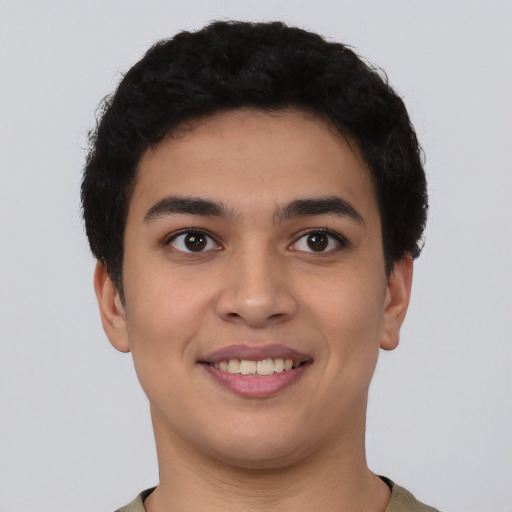 Joyful latino young-adult male with short  brown hair and brown eyes