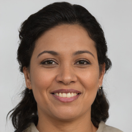 Joyful latino adult female with medium  brown hair and brown eyes