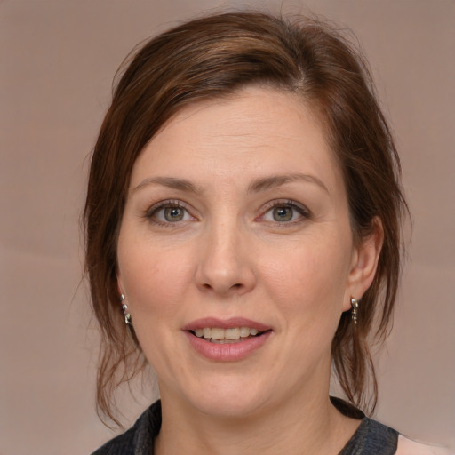 Joyful white adult female with medium  brown hair and grey eyes