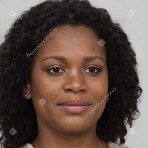 Joyful black young-adult female with long  brown hair and brown eyes