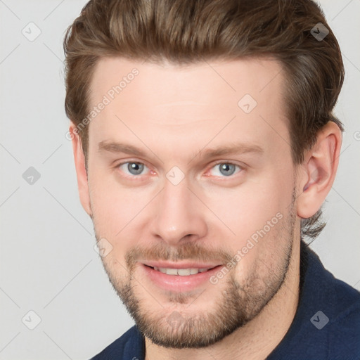 Joyful white young-adult male with short  brown hair and grey eyes