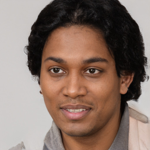 Joyful black young-adult male with short  brown hair and brown eyes