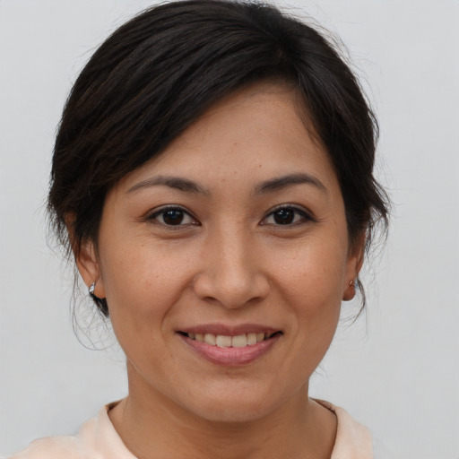 Joyful asian adult female with medium  brown hair and brown eyes