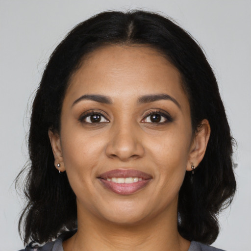 Joyful latino young-adult female with long  brown hair and brown eyes