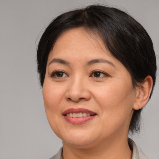 Joyful asian adult female with medium  brown hair and brown eyes